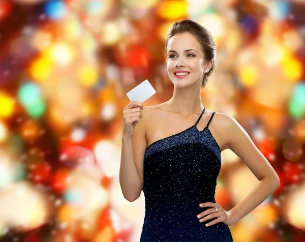 Mulher sorridente em vestido de noite segurando cartão de crédito — Fotografia de Stock