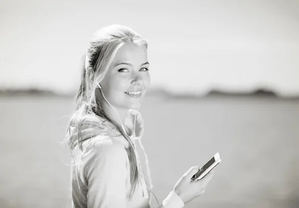 Vrouw die buiten naar muziek luistert — Stockfoto