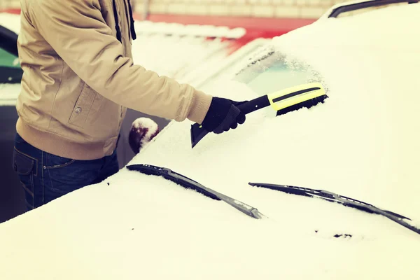 Fechar-se do homem limpando a neve do carro — Fotografia de Stock