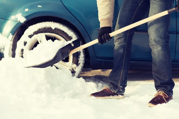 Closeup of man digging up stuck in snow car — Stock Photo, Image