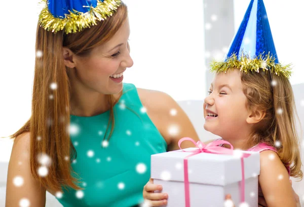 Mãe e filha em chapéus de festa com caixa de presente — Fotografia de Stock