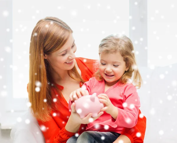 Moeder en dochter met piggy bank — Stockfoto