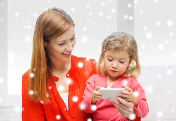 Lycklig mor och dotter med smartphone hemma — Stockfoto