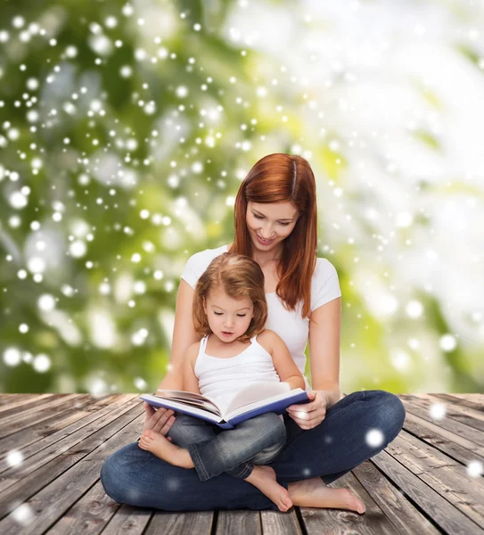 Madre feliz con niña y libro — Foto de Stock