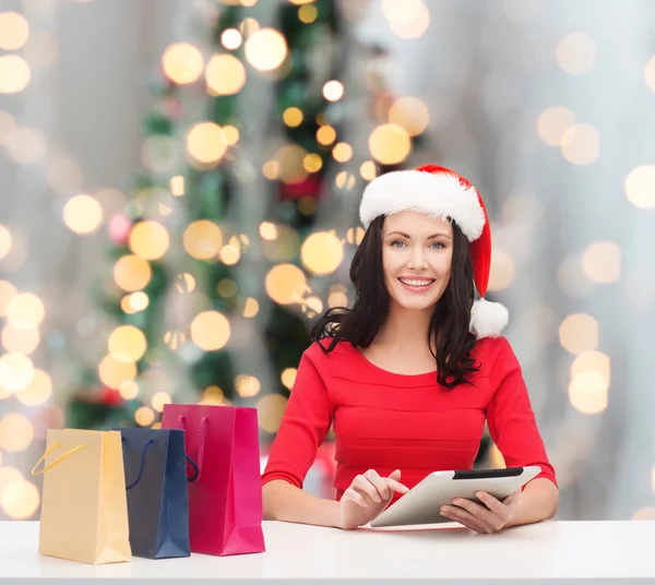 Smiling woman with shopping bags and tablet pc — Stock Photo, Image