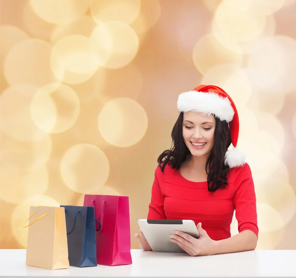 Lächelnde Frau mit Einkaufstaschen und Tablet-PC — Stockfoto