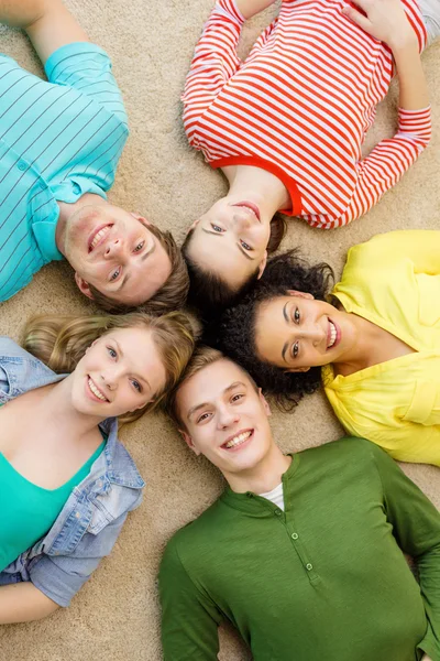 Grupo de personas sonrientes tumbadas en el suelo — Foto de Stock