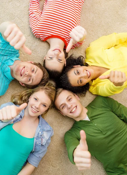 Grupa osób uśmiechający się leżącej na podłodze — Zdjęcie stockowe