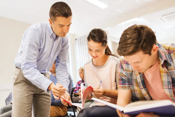 Group of students and teacher with notebook — Stock Photo, Image