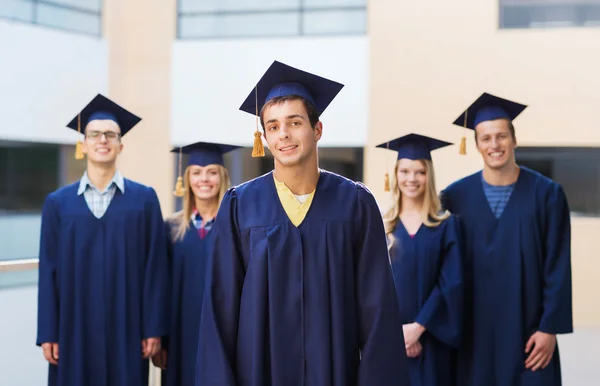 Grup gülümseyen öğrenci mortarboards içinde — Stok fotoğraf