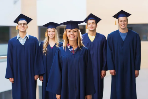 Grup gülümseyen öğrenci mortarboards içinde — Stok fotoğraf