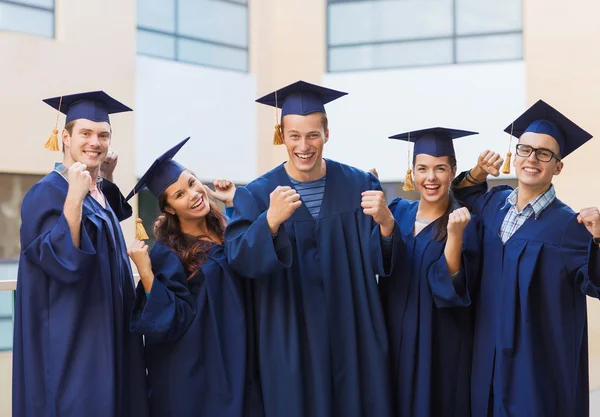 Group of smiling students in mortarboards — Stock Photo, Image