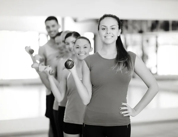 Gruppo di persone sorridenti con i manubri in palestra — Foto Stock