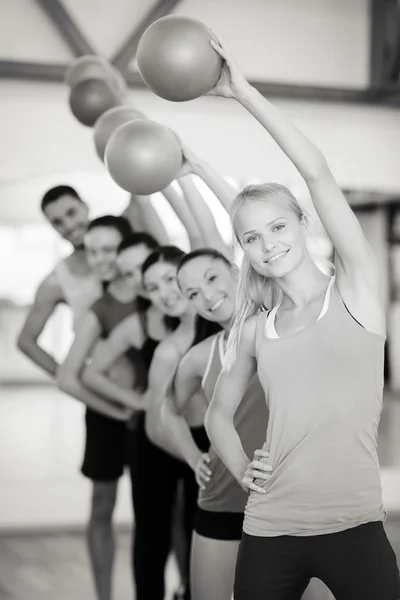 Groep lachende mensen uit te werken met de bal — Stockfoto