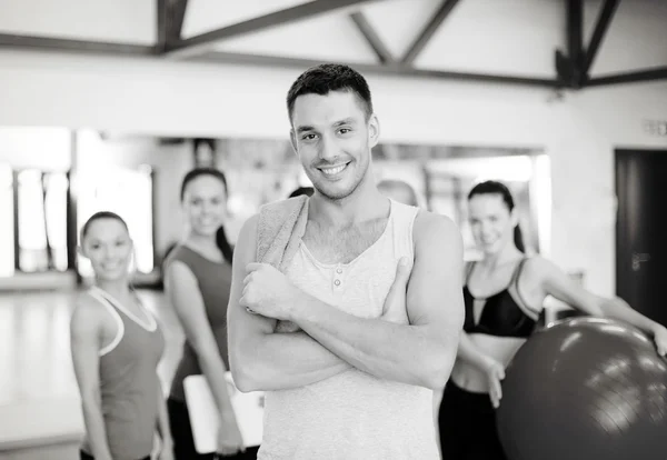 Sonriente hombre de pie frente al grupo en el gimnasio —  Fotos de Stock