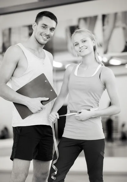 Two smiling people with clipboard and measure tape — Stock Photo, Image