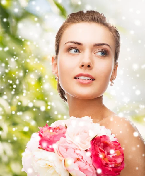 Femme avec boucles d'oreilles en diamant, bague et fleur — Photo