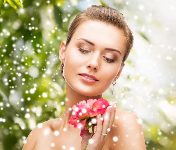 Mulher com brincos de diamante, anel e flor — Fotografia de Stock