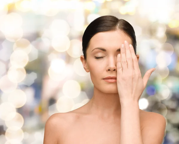 Lächelnde junge Frau bedeckt Gesicht mit Hand — Stockfoto