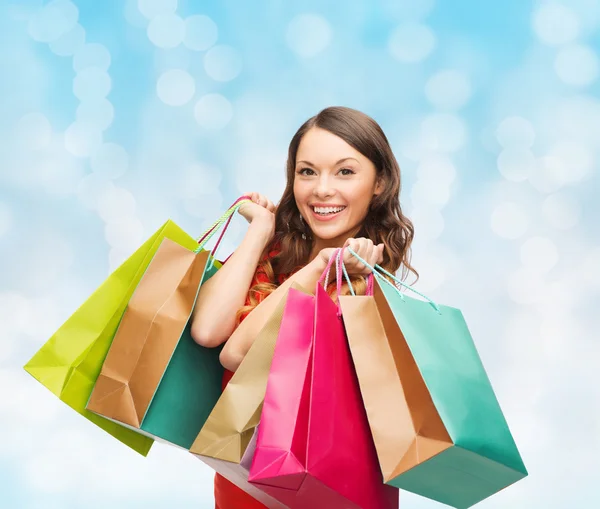 Mulher sorridente com sacos de compras coloridos — Fotografia de Stock