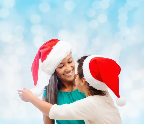 幸福的母亲和女孩在圣诞老人的帽子 — 图库照片