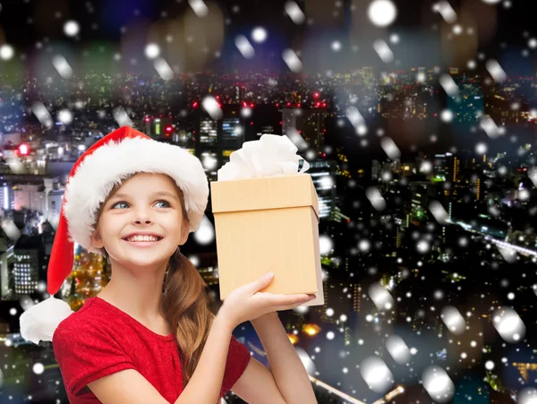 Lachende meisje in helper kerstmuts met een doos van de gift — Stockfoto