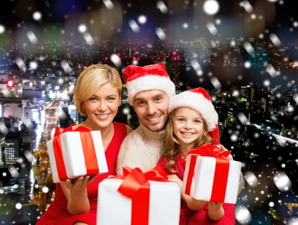 Lycklig familj i santa helper hattar med presentförpackning — Stockfoto