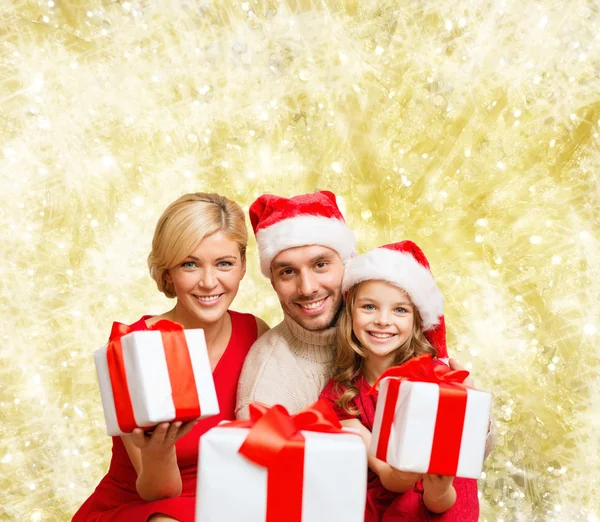 Família feliz em santa helper chapéus com caixas de presente — Fotografia de Stock