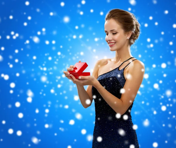 Улыбающаяся женщина с красной коробкой подарков — стоковое фото