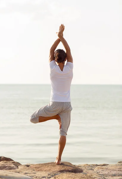 Joven haciendo ejercicios de yoga al aire libre — Foto de Stock