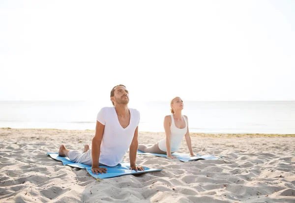 Paar maken yoga oefeningen buiten — Stockfoto