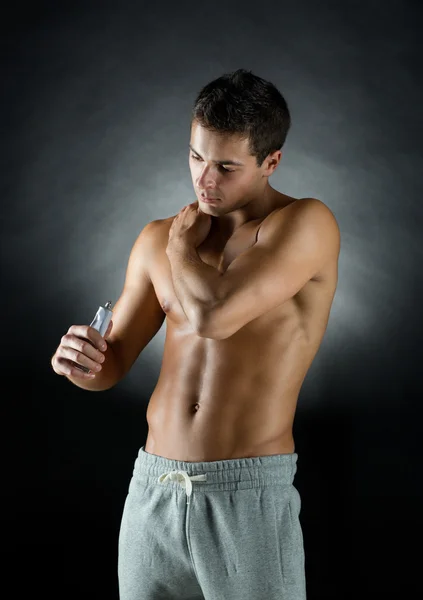 Young male bodybuilder applying pain relief gel — Stock Photo, Image