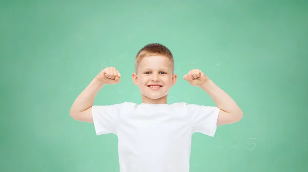 Heureux petit garçon en t-shirt blanc flexion biceps — Photo