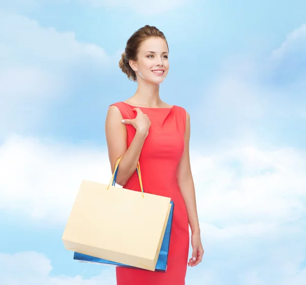 Uśmiechający się elegancka kobieta w sukni z torby na zakupy — Zdjęcie stockowe