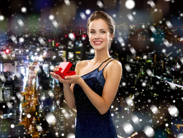 Mujer sonriente en vestido de noche con caja de regalo —  Fotos de Stock