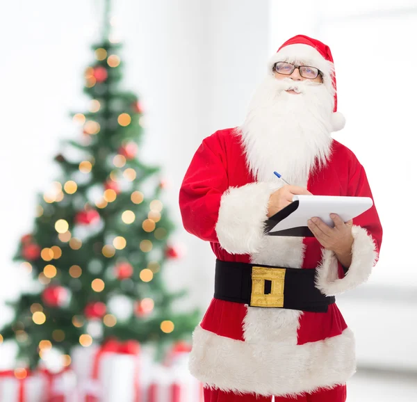 Homem em traje de santa claus com bloco de notas — Fotografia de Stock