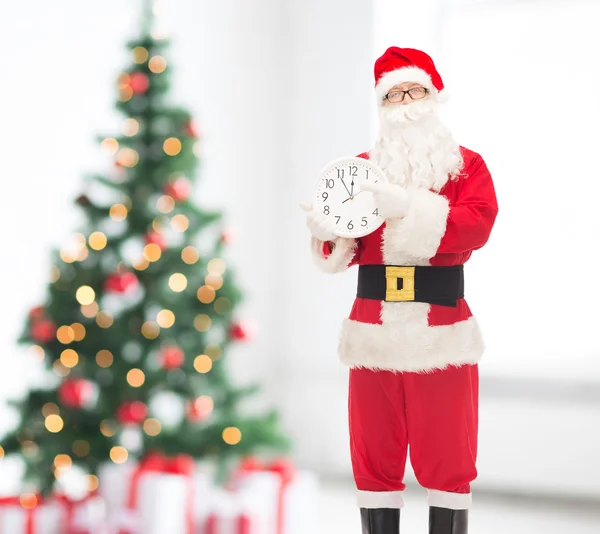 Homme en costume de Père Noël claus avec horloge — Photo