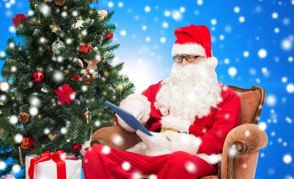 Man in costume of santa claus with tablet pc — Stock Photo, Image