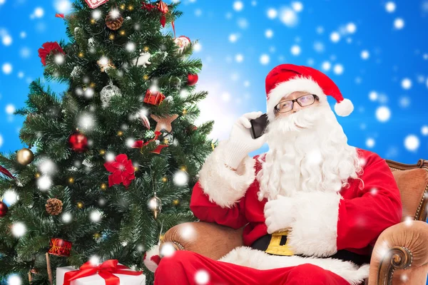 Jultomte med smartphone och julgran — Stockfoto