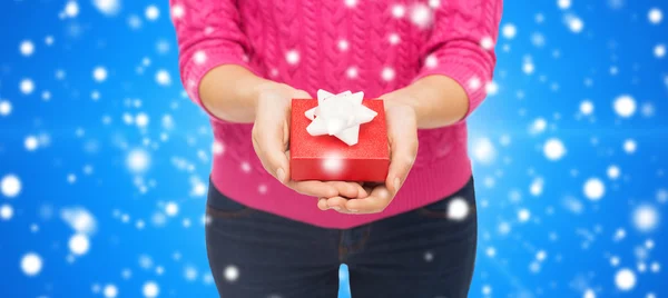 Close up of woman in pink sweater holding gift box — Stock Photo, Image