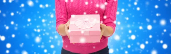 Primer plano de la mujer en suéter rosa celebración caja de regalo — Foto de Stock