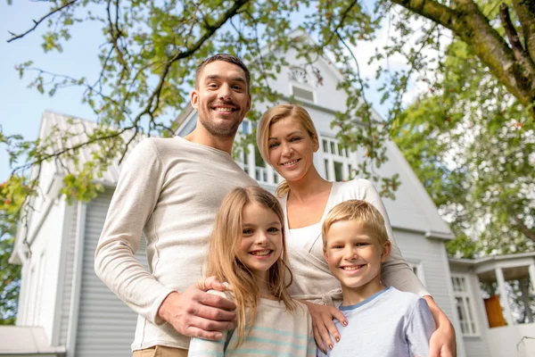 Ευτυχισμένη οικογένεια μπροστά από το σπίτι σε εξωτερικούς χώρους — Φωτογραφία Αρχείου