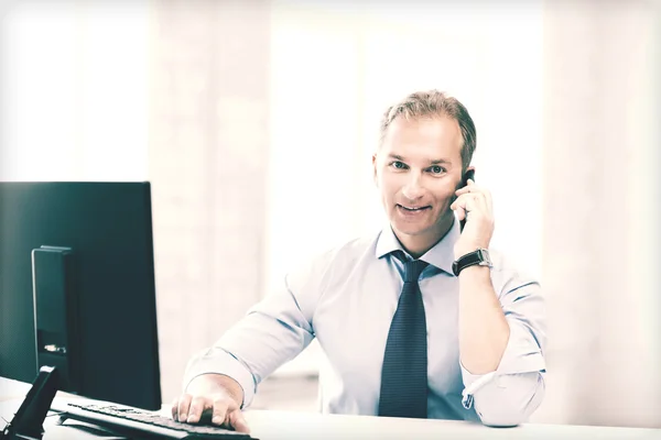 Lachende zakenman met smartphone in office — Stockfoto