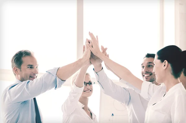 Happy business team ger hög fem i office — Stockfoto