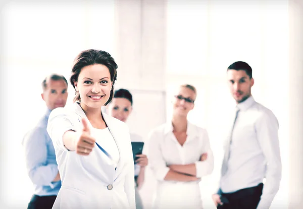 Businesswoman in office showing thumbs up — Stock Photo, Image