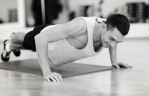 Uomo sorridente che fa flessioni in palestra — Foto Stock