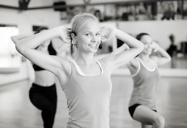 Grupo de personas sonrientes haciendo ejercicio en el gimnasio —  Fotos de Stock