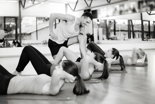 Grupo de mujeres sonrientes haciendo sentadas en el gimnasio — Foto de Stock