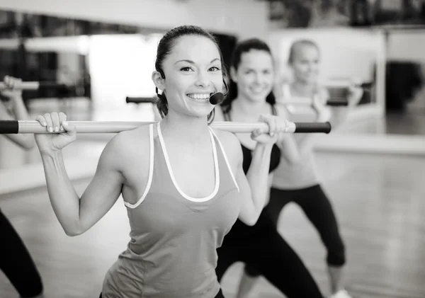 Group of smiling people working out with barbells — Stock Photo, Image
