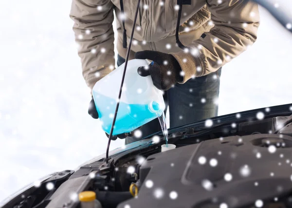 Großaufnahme eines Mannes, der Frostschutzmittel ins Auto schüttet — Stockfoto